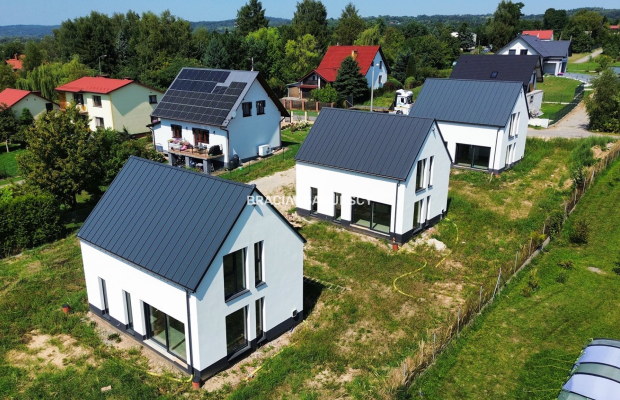 Nowe domy w sąsiedztwie terenów zielonych / Ujazd